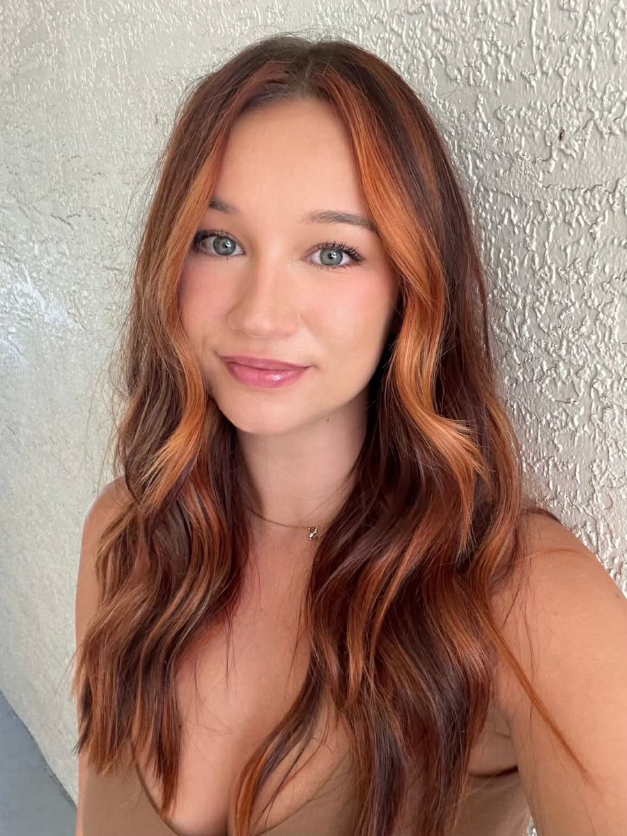 Warm, rustic Cowboy Copper hair color with pops of copper balayage for added dimension.