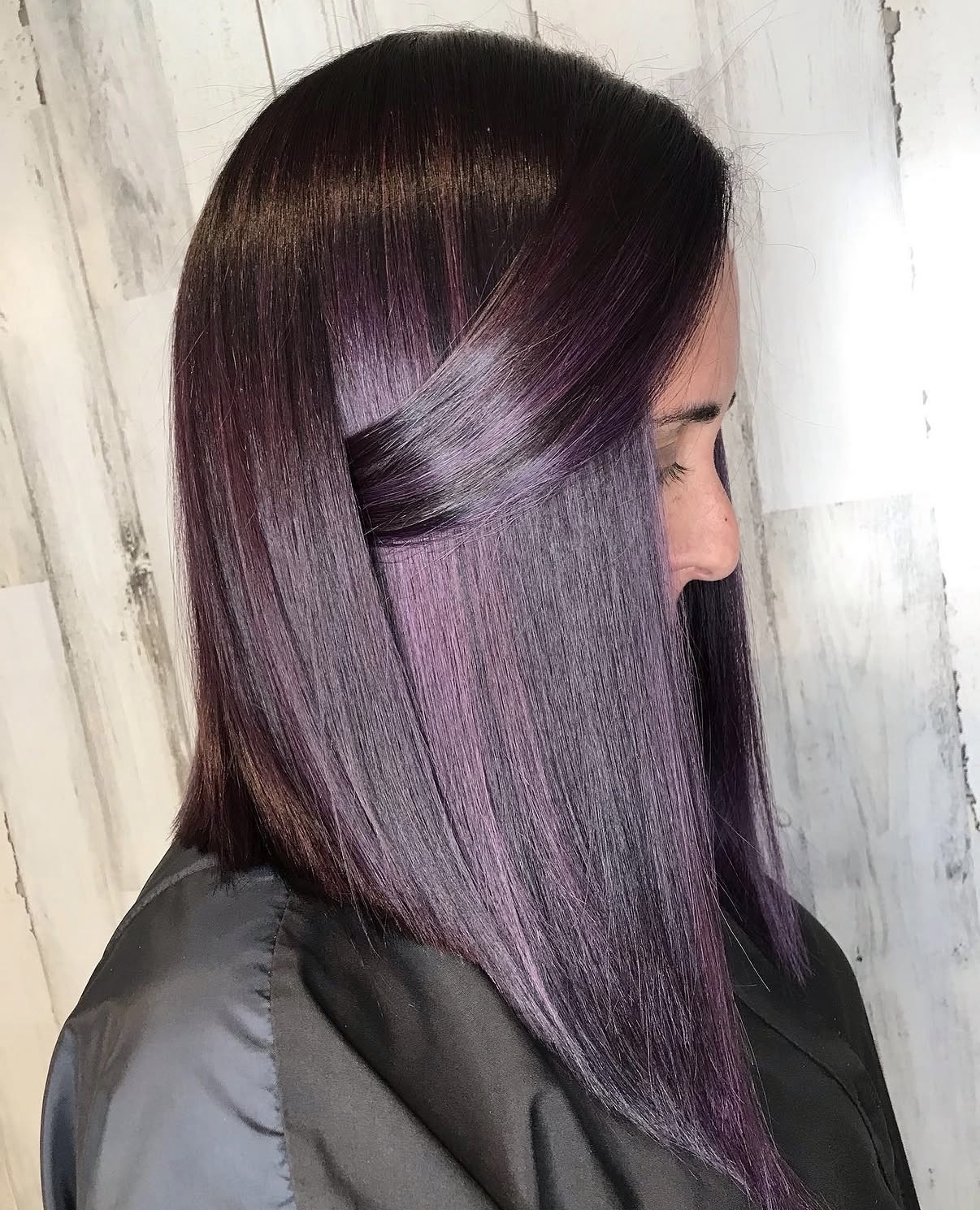 A rich plum base hair color accented with brighter violet highlights created with permanent fashion color.