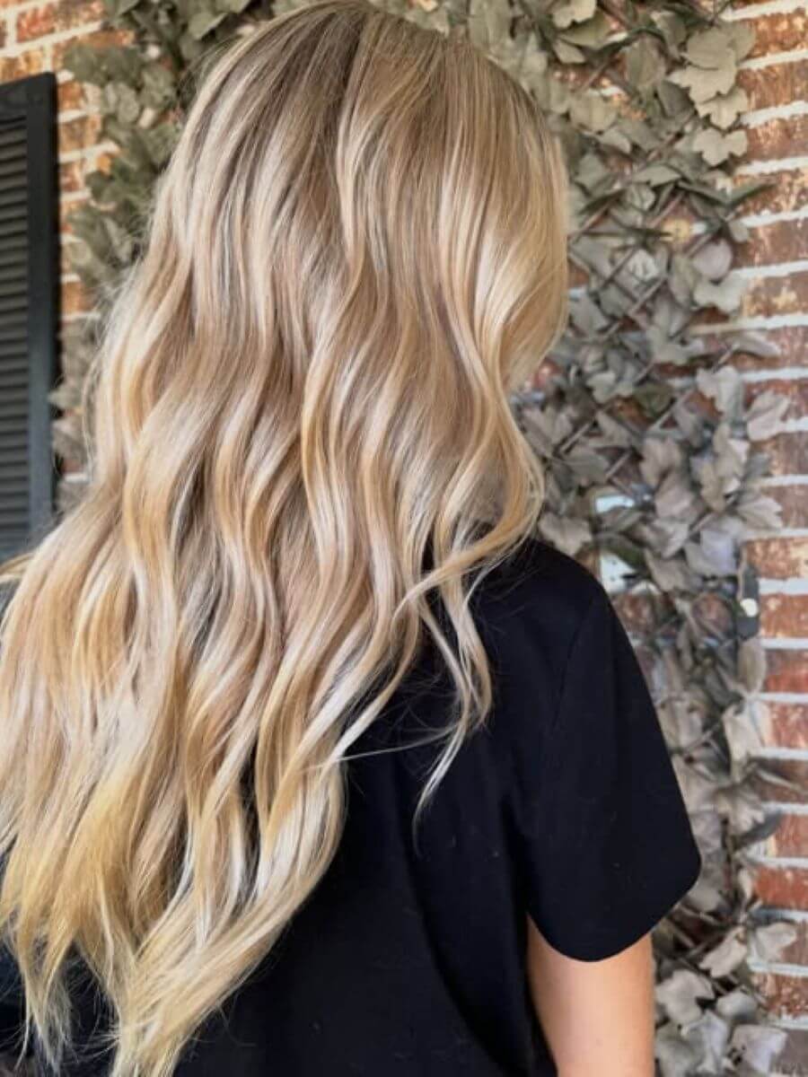 Champagne blonde hair with soft, neutral tones and a glossy, luminous finish.