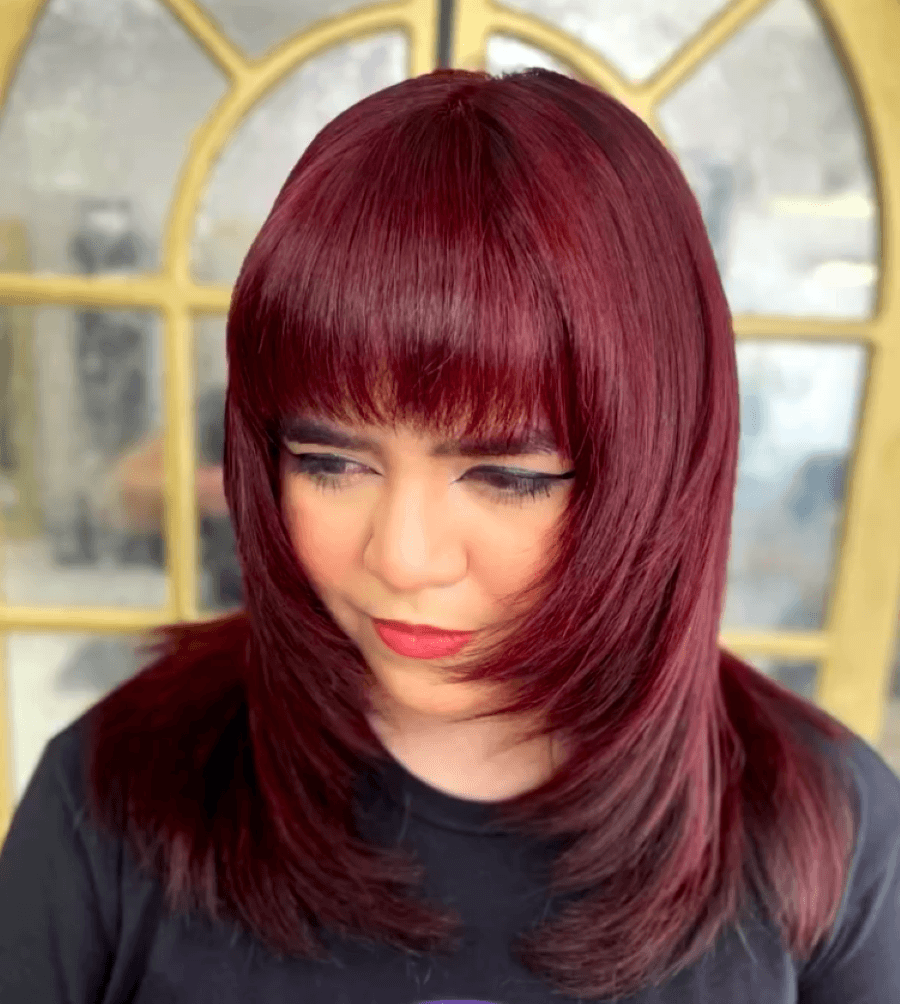 Glossy cherry red hair color with vibrant red tones and a cool, glossy finish.